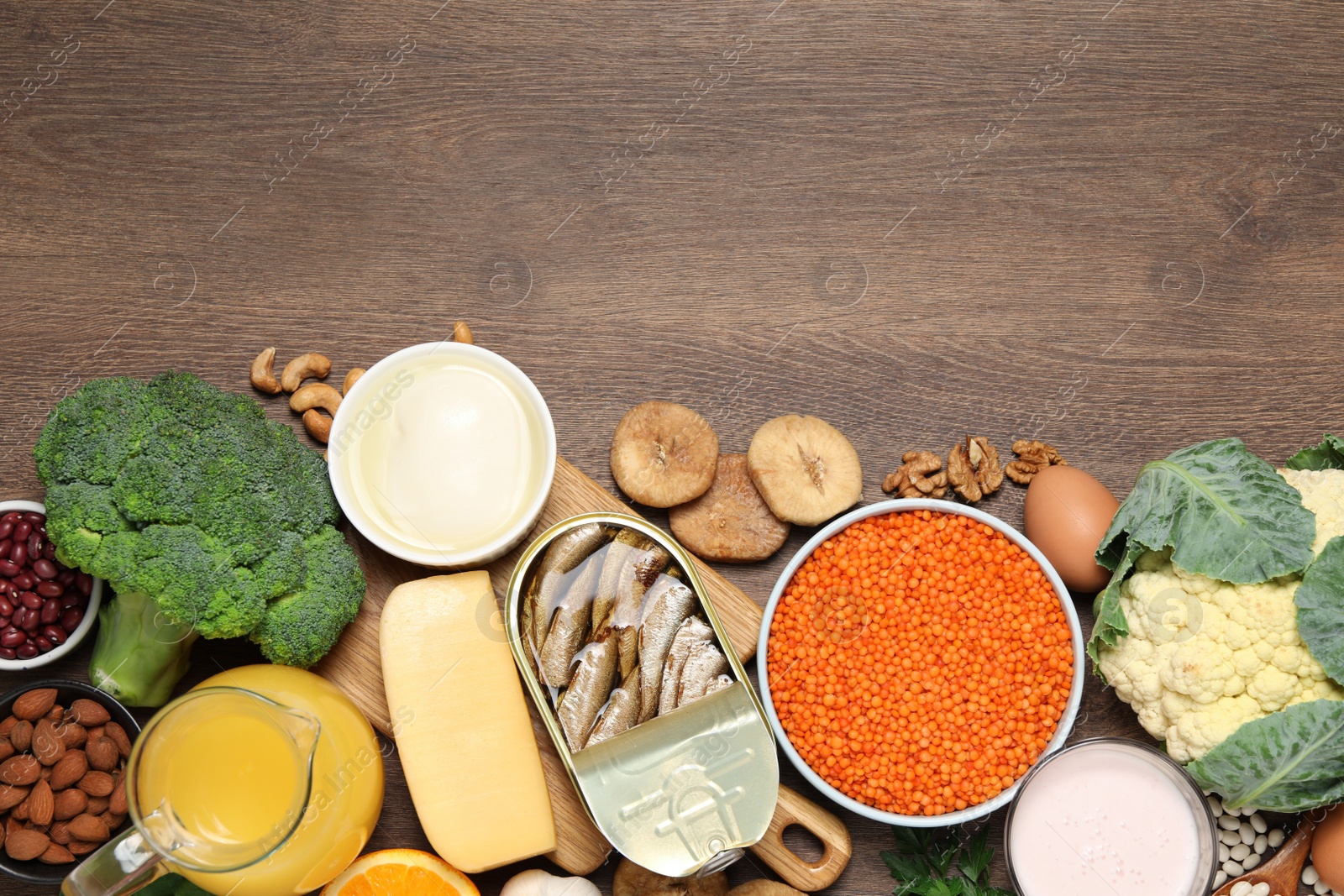 Photo of Set of natural food high in calcium on wooden table, flat lay. Space for text