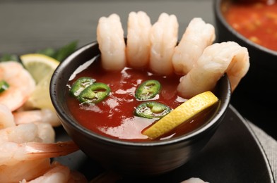 Photo of Tasty shrimp cocktail with sauce on table, closeup