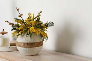 Photo of Beautiful mimosa flowers in vase on wooden table, space for text