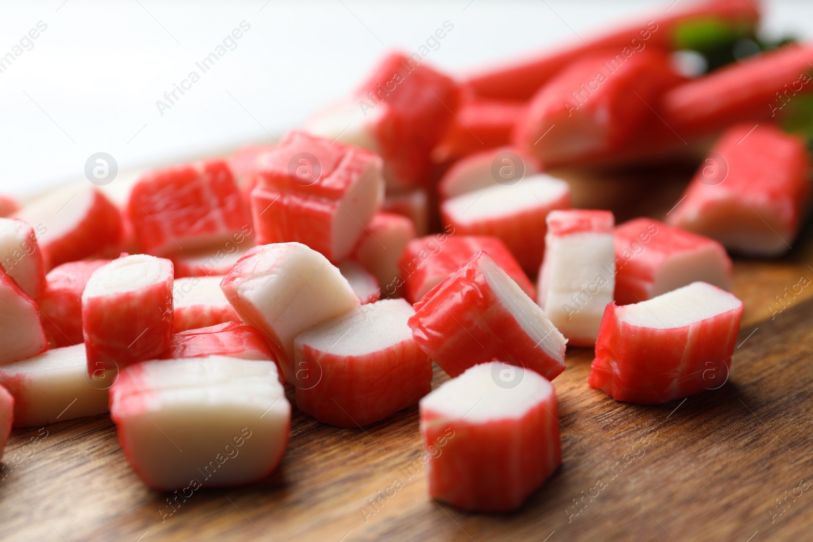 Photo of Delicious crab sticks on wooden board, closeup