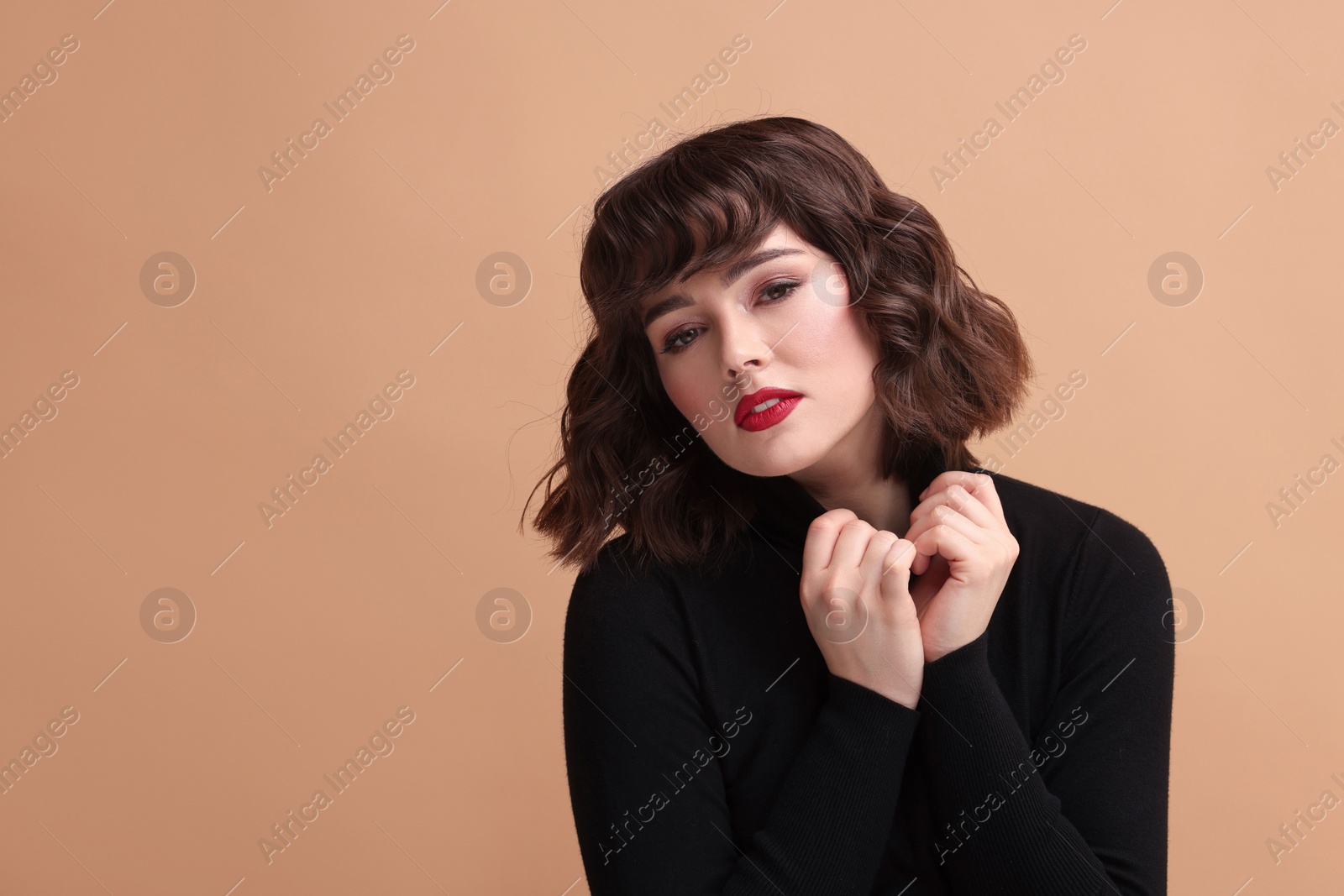 Photo of Portrait of beautiful young woman with wavy hairstyle on beige background. Space for text
