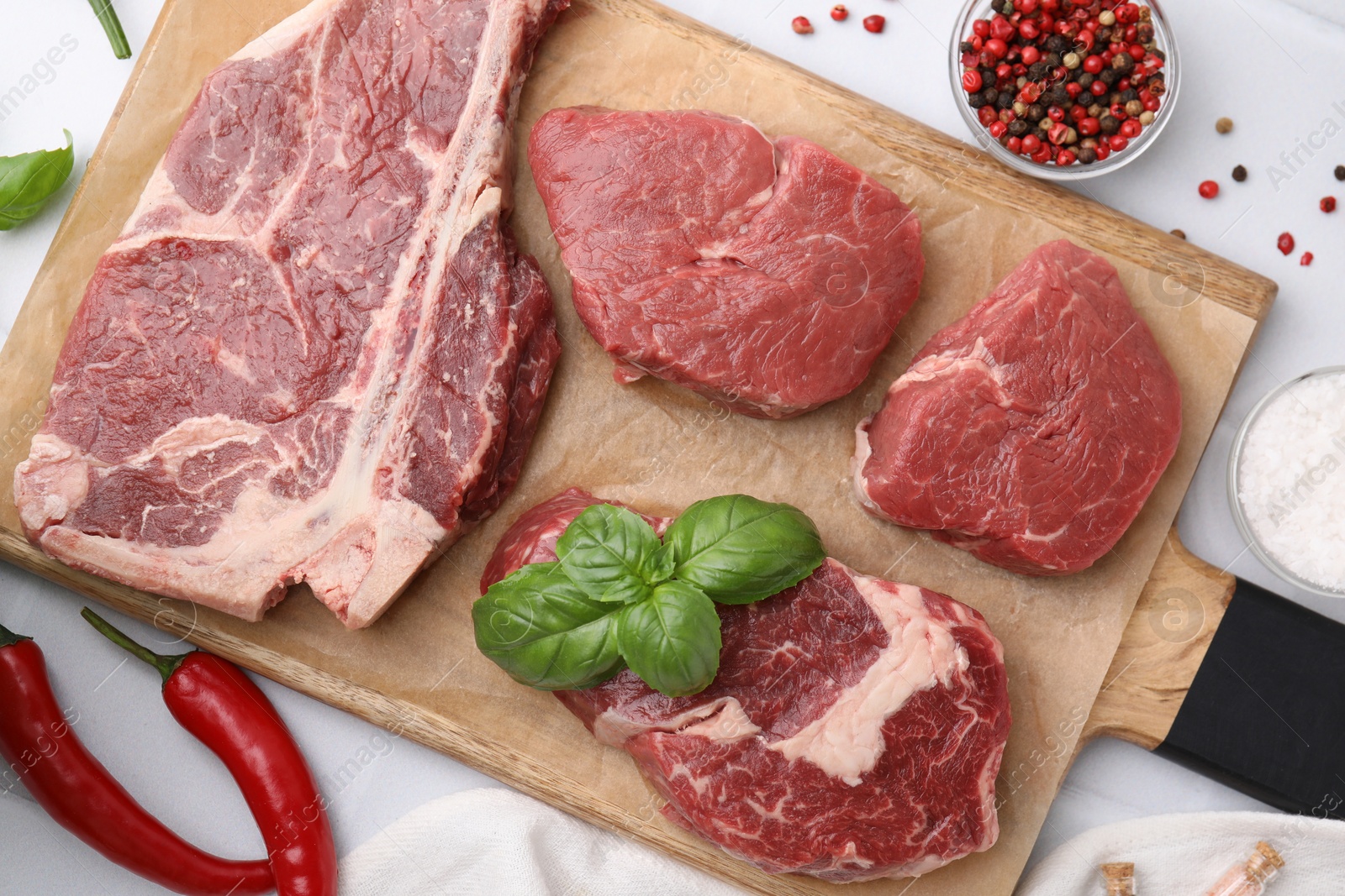 Photo of Flat lay composition with cut fresh beef meat and spices on white table