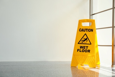 Safety sign with phrase Caution wet floor, indoors. Cleaning service