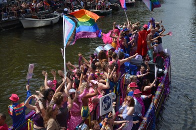 AMSTERDAM, NETHERLANDS - AUGUST 06, 2022: Many people in boats at LGBT pride parade on river