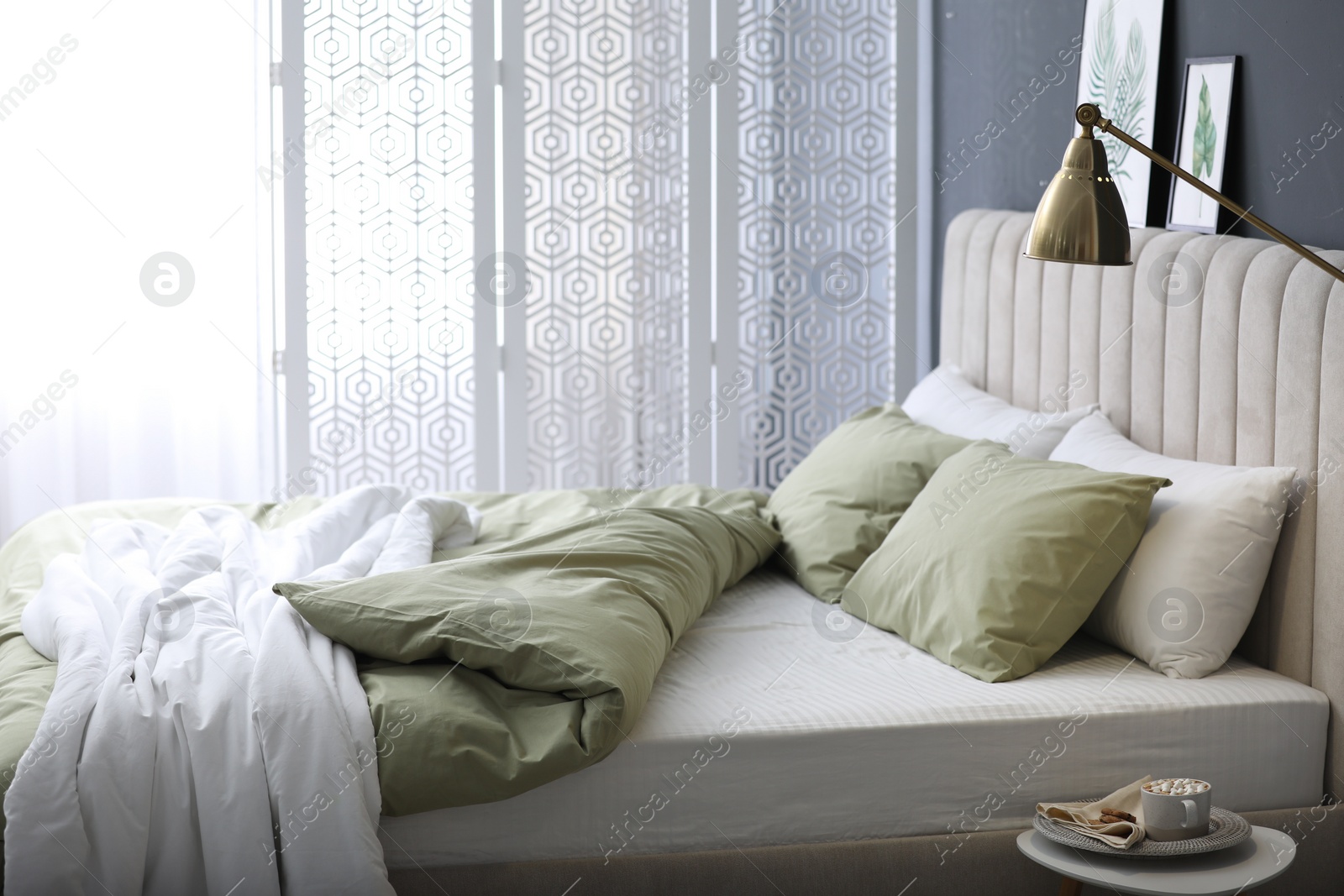 Photo of Comfortable bed with new pistachio linens in modern room interior