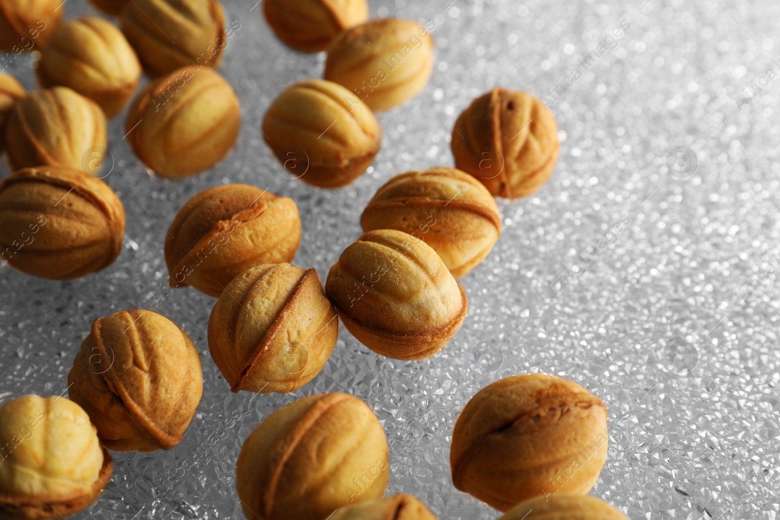 Photo of Freshly baked walnut shaped cookies on glass table, closeup and space for text. Homemade pastry filled with caramelized condensed milk
