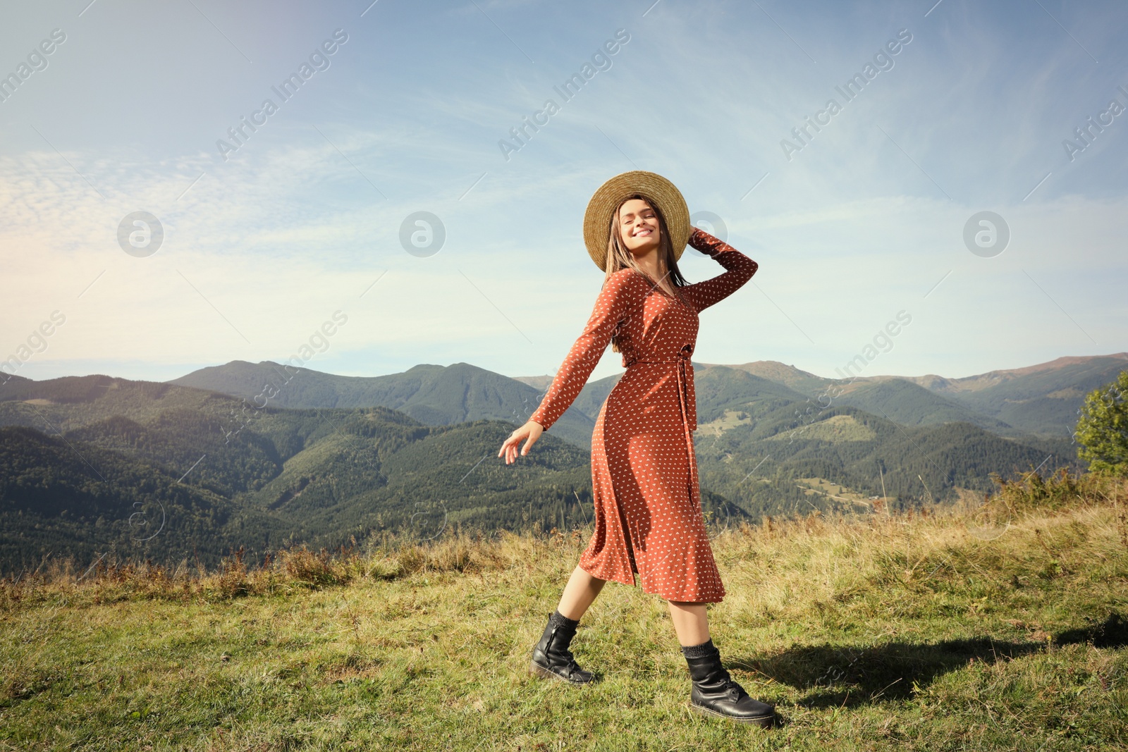 Photo of Young woman with hat walking in beautiful mountains on sunny day