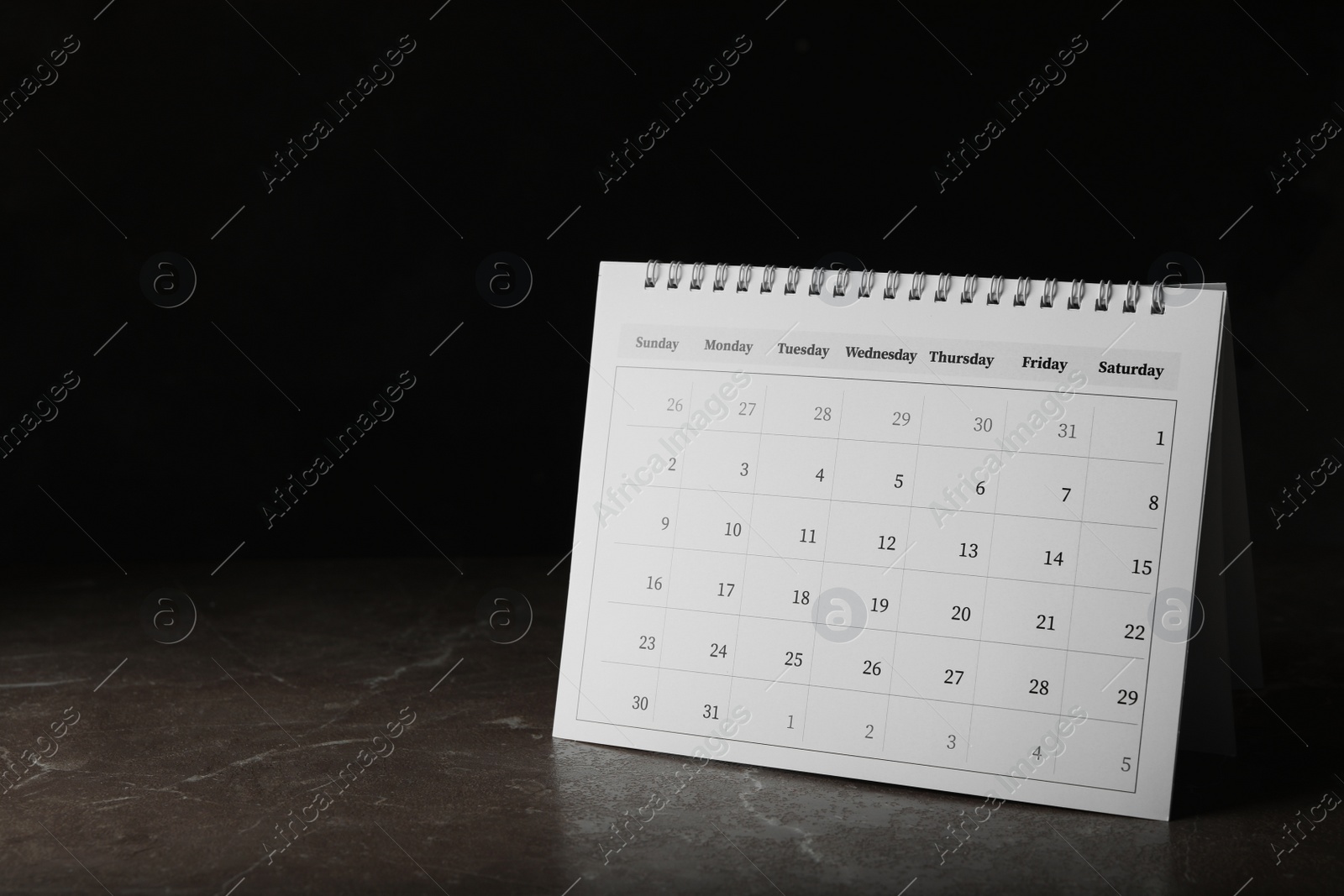 Photo of Paper calendar on stone table, space for text. Planning concept