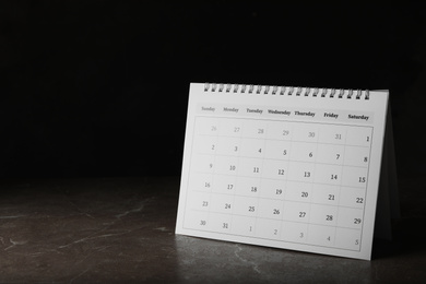Photo of Paper calendar on stone table, space for text. Planning concept