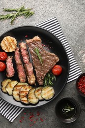 Photo of Delicious grilled beef steak with vegetables and spices on gray table, flat lay