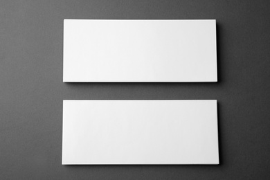 Photo of Blank business cards on dark grey background, flat lay. Mock up for design
