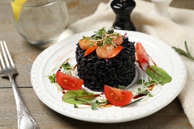 Photo of Delicious black risotto with seafood served on plate