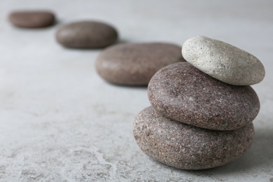 Stacked spa stones on grey table. Space for text