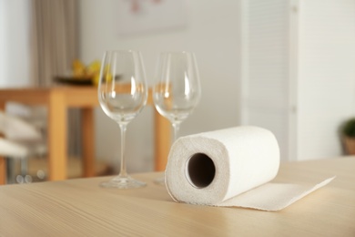 Photo of Roll of paper towels and glasses on table indoors. Space for text