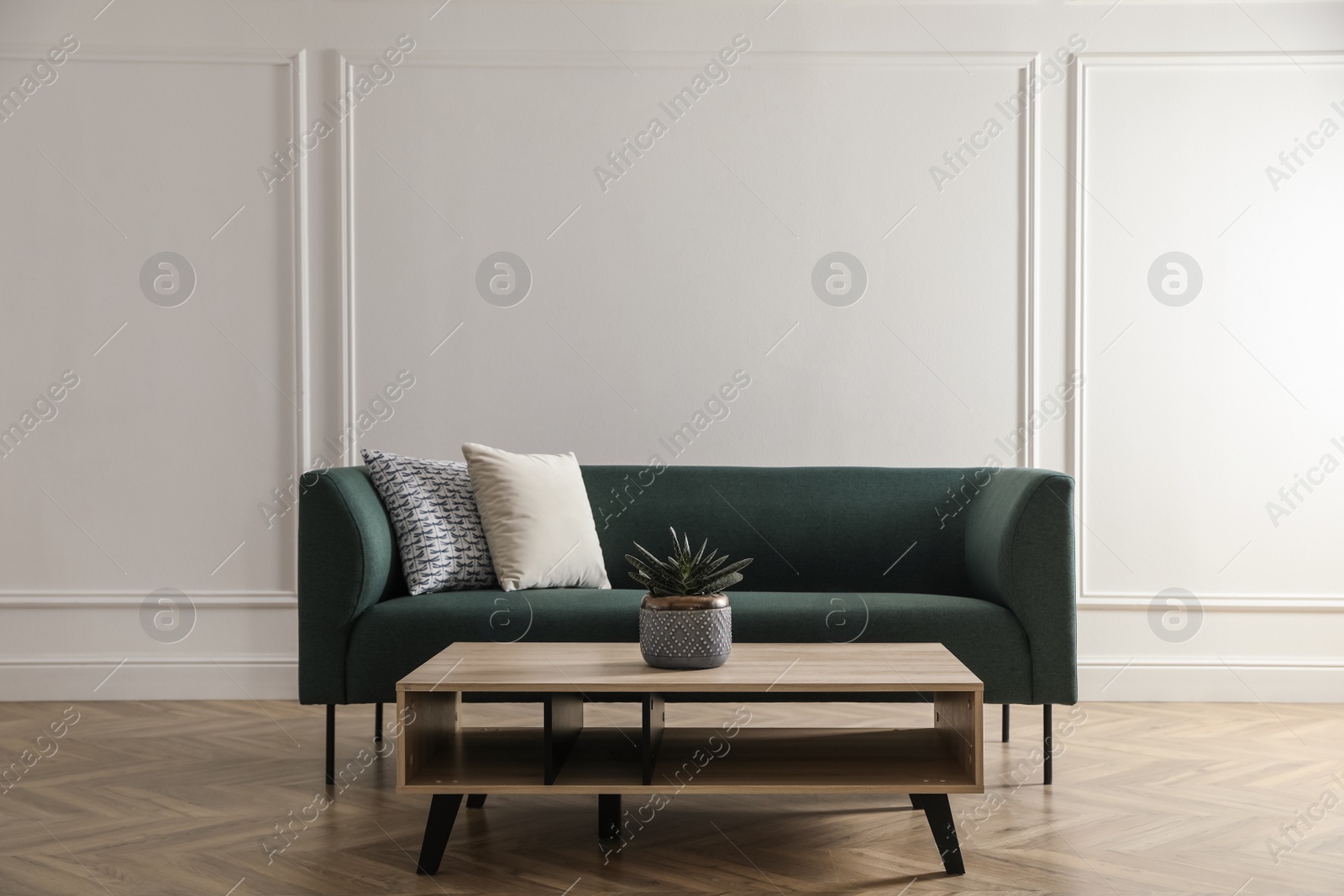 Photo of Stylish living room interior with comfortable green sofa and wooden table