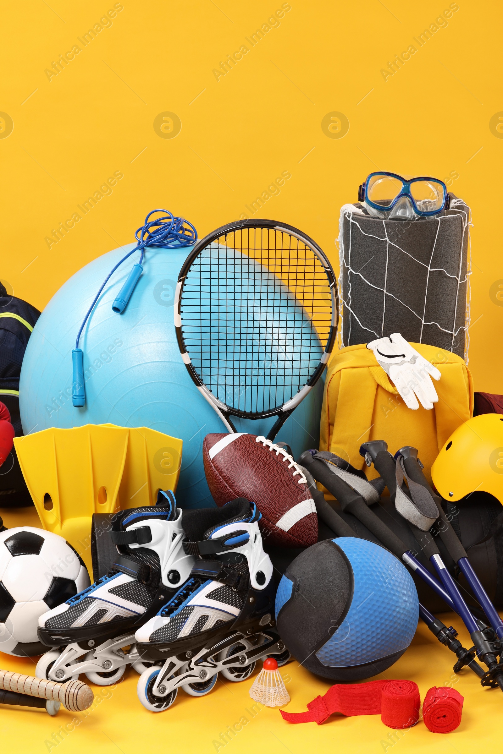 Photo of Many different sports equipment on yellow background