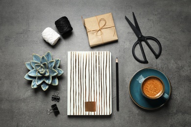Photo of Flat lay composition with scissors, notebook and coffee on grey table