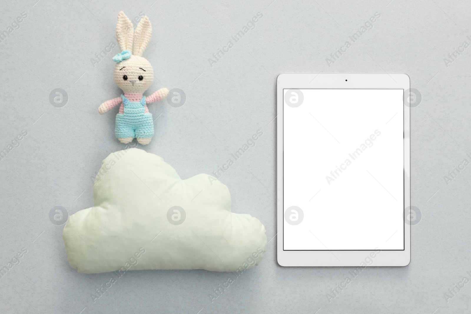 Photo of Modern tablet, toy cloud and bunny on light background, flat lay. Space for text