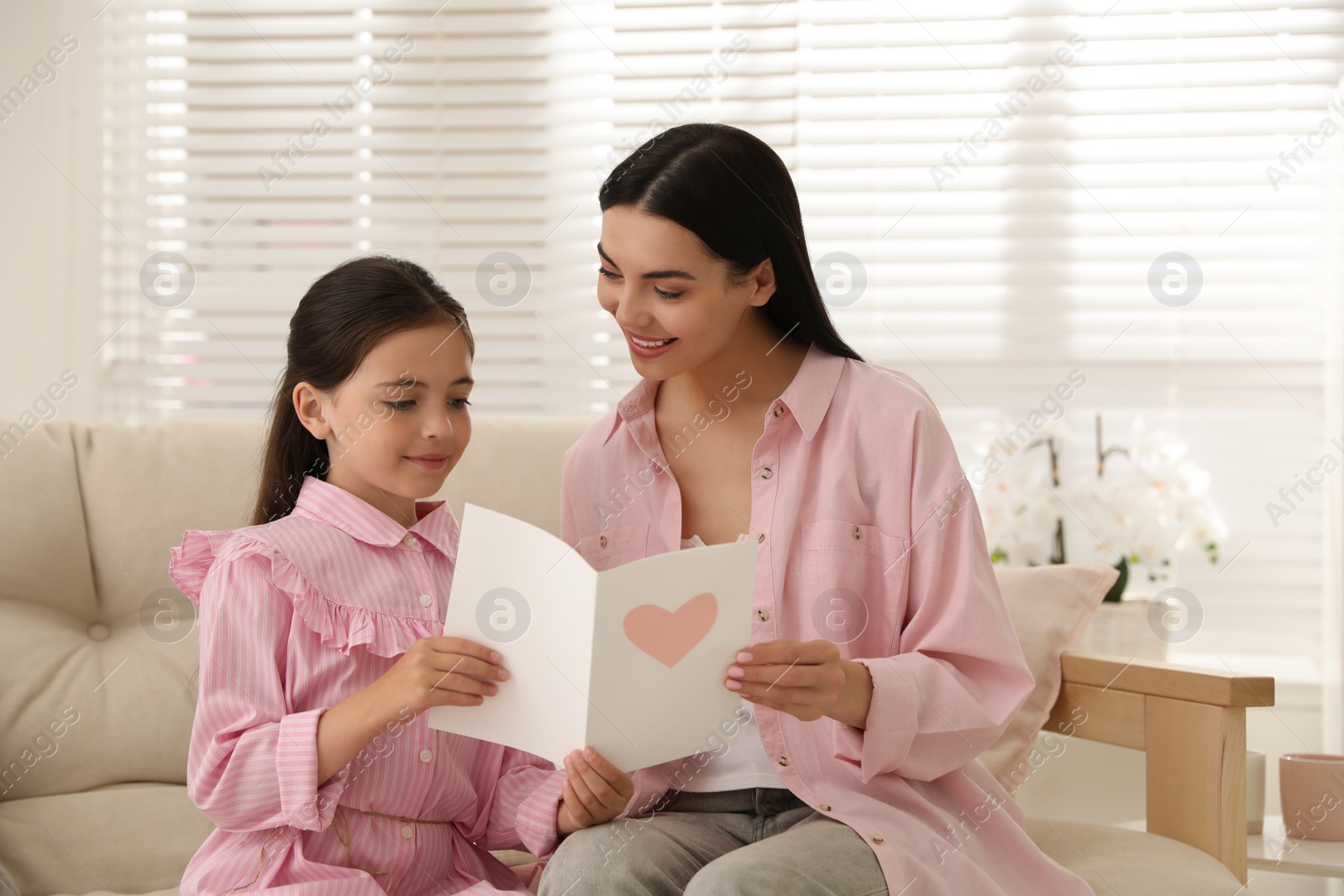 Photo of Little daughter congratulating her mom at home. Happy Mother's Day