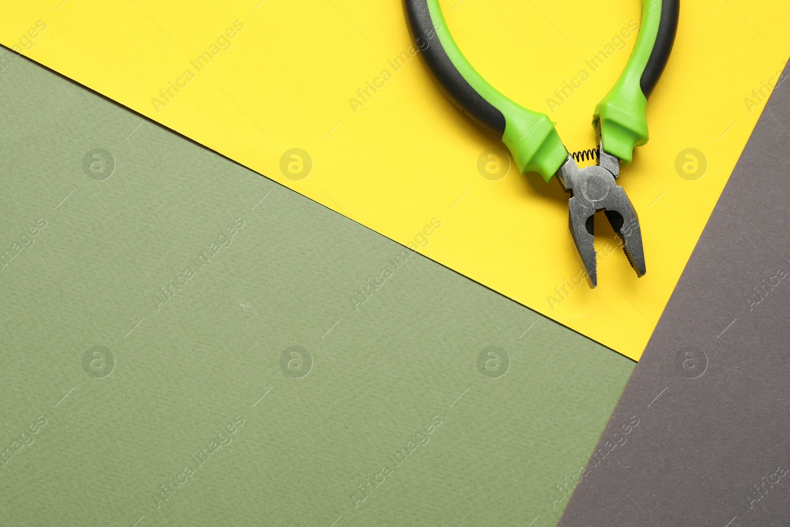 Photo of Combination pliers on color background, top view. Space for text