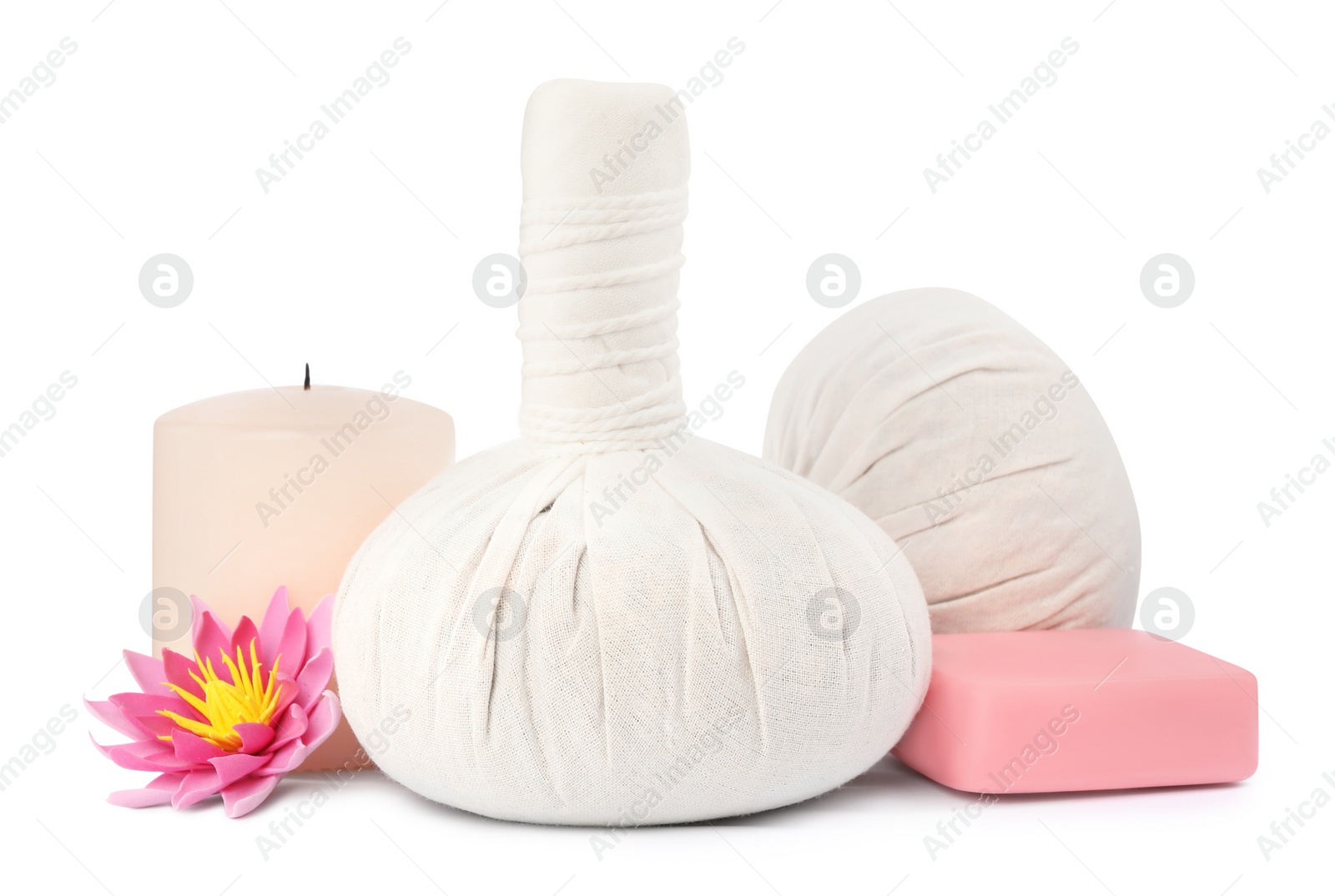 Photo of Herbal massage bags, candle, flower and soap on white background. Spa supply