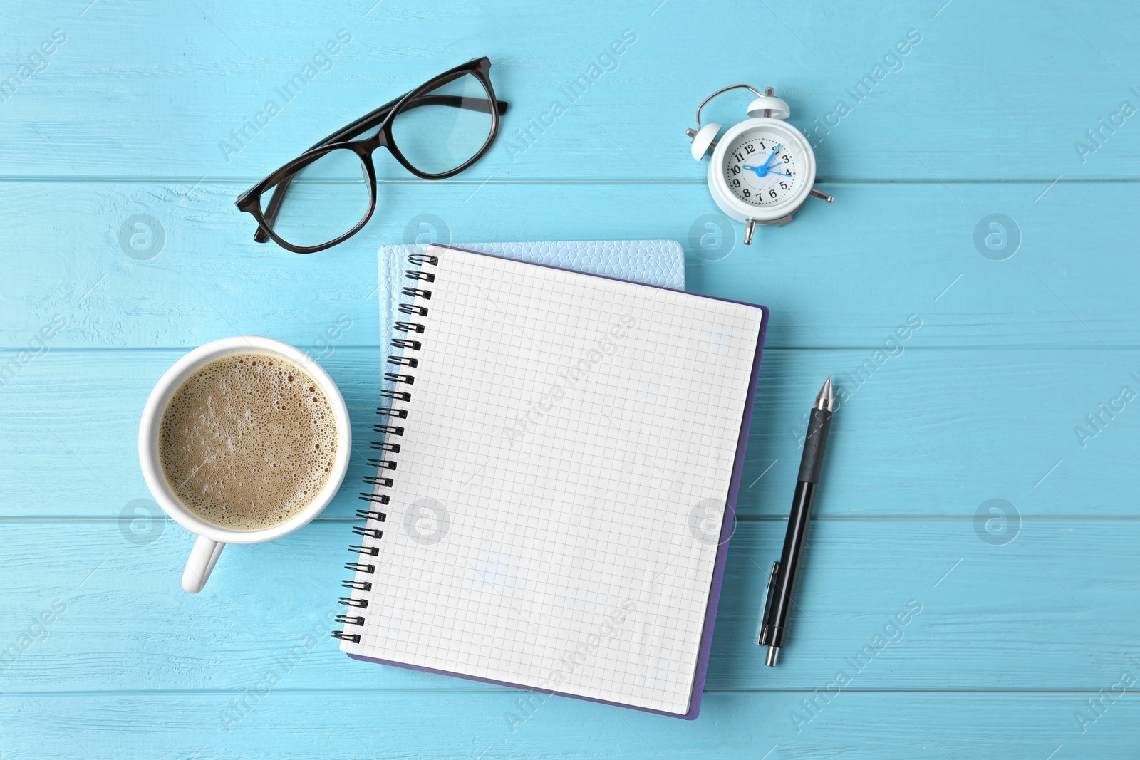 Photo of Flat lay composition with office stationery and cup of coffee on light blue wooden table. Space for text