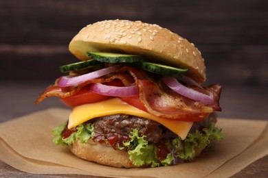 Photo of Tasty burger with bacon, vegetables and patty on table, closeup