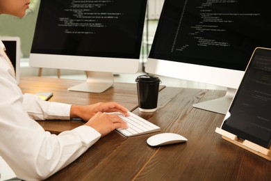 Photo of Programmer working at desk in office, closeup