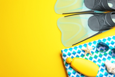 Photo of Flat lay composition beach accessories on yellow background, space for text