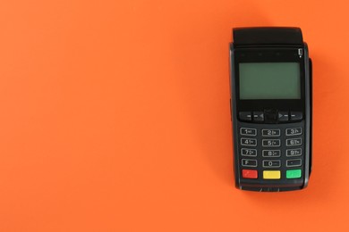 New modern payment terminal on orange background, top view. Space for text