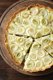 Photo of Board with tasty leek pie on wooden table, top view