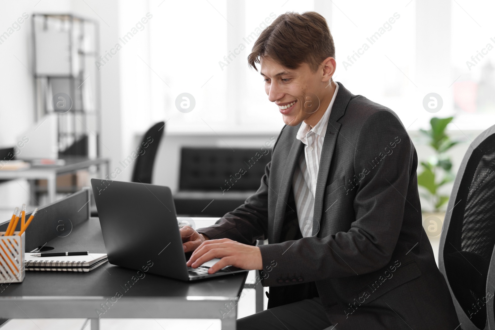 Photo of Man watching webinar at table in office