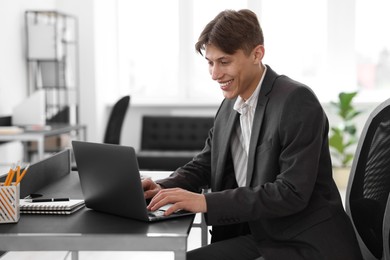 Photo of Man watching webinar at table in office