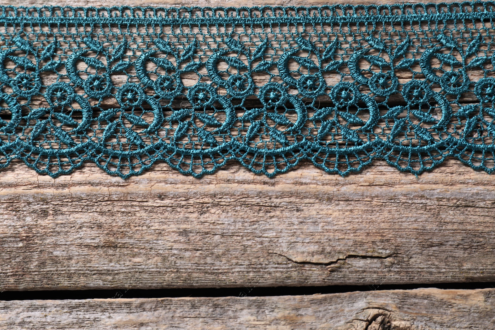 Photo of Beautiful lace on wooden table, top view. Space for text