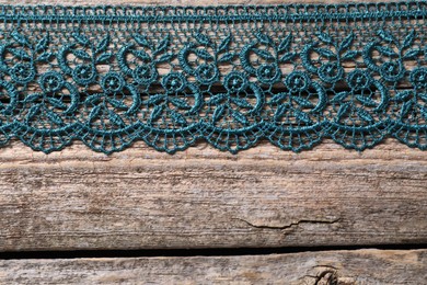 Photo of Beautiful lace on wooden table, top view. Space for text