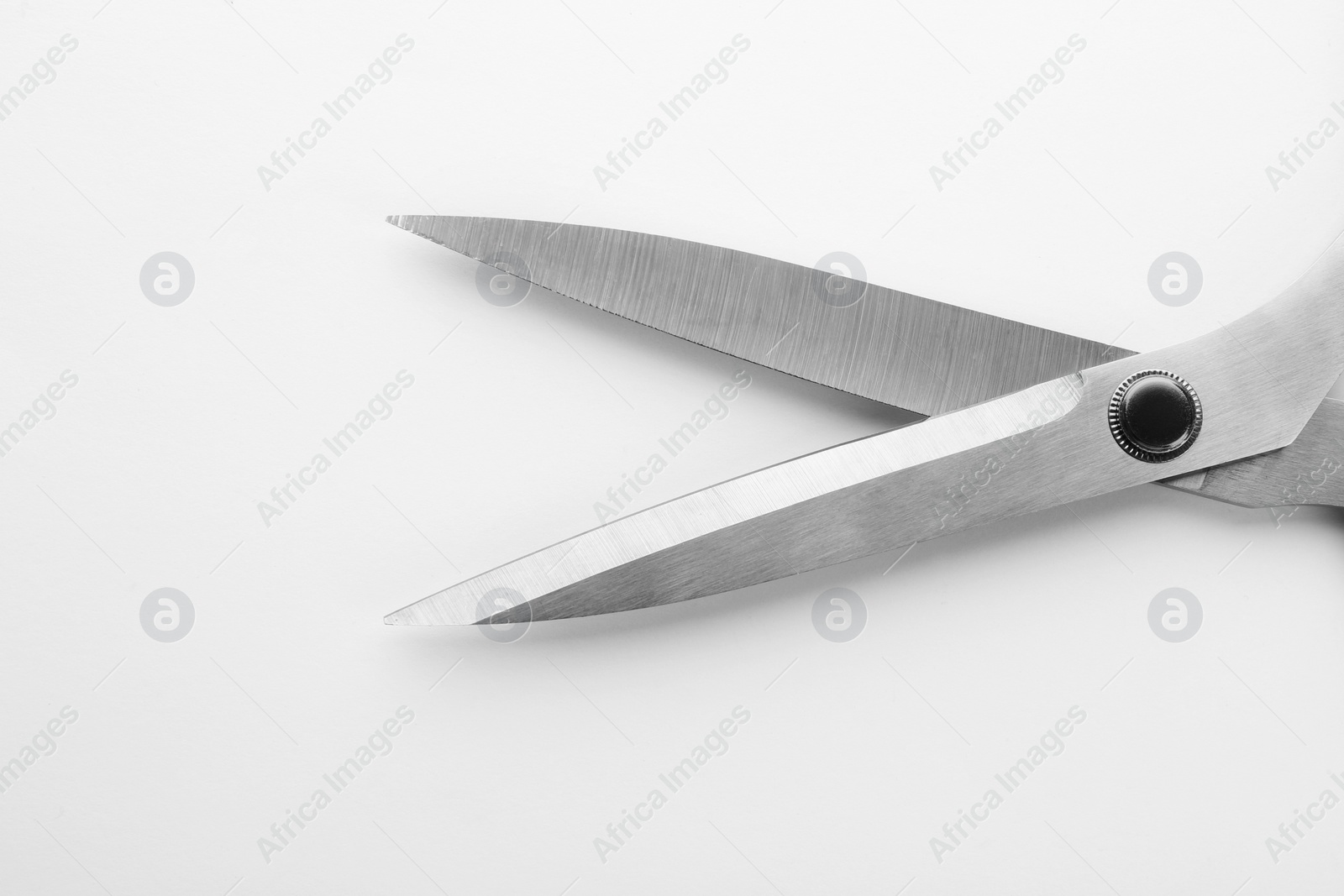 Photo of Pair of sharp sewing scissors on white background, closeup