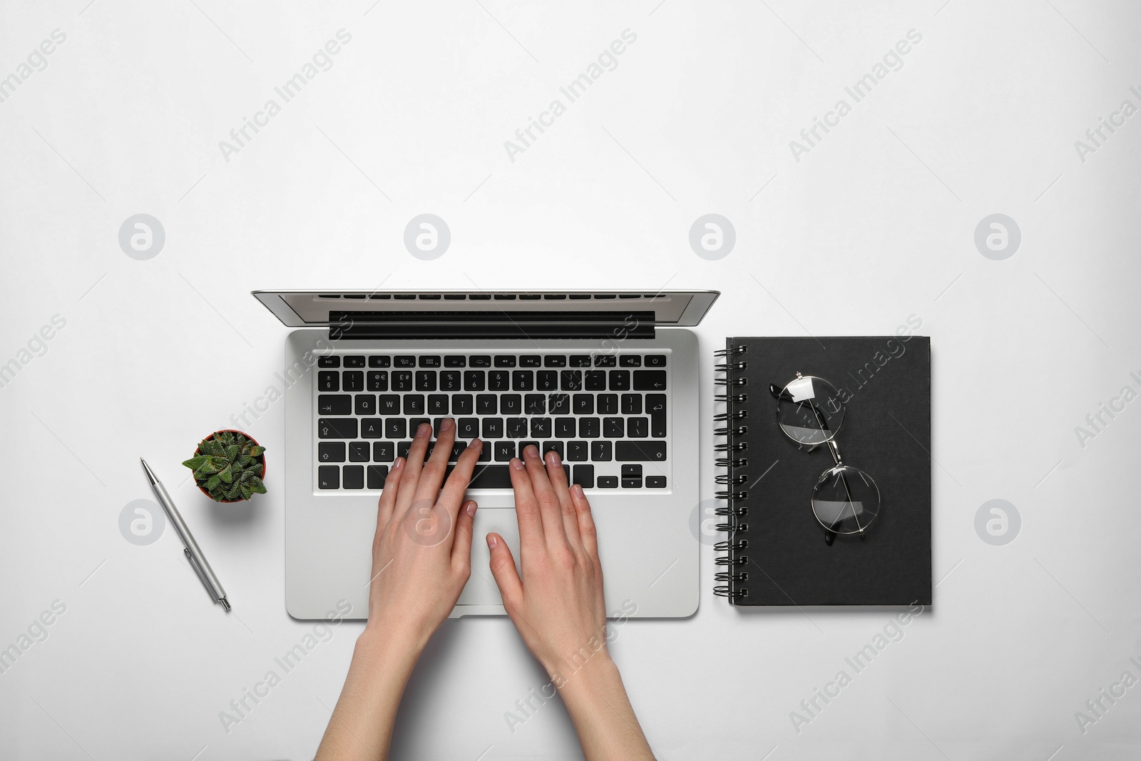 Photo of Woman using laptop at white table, top view