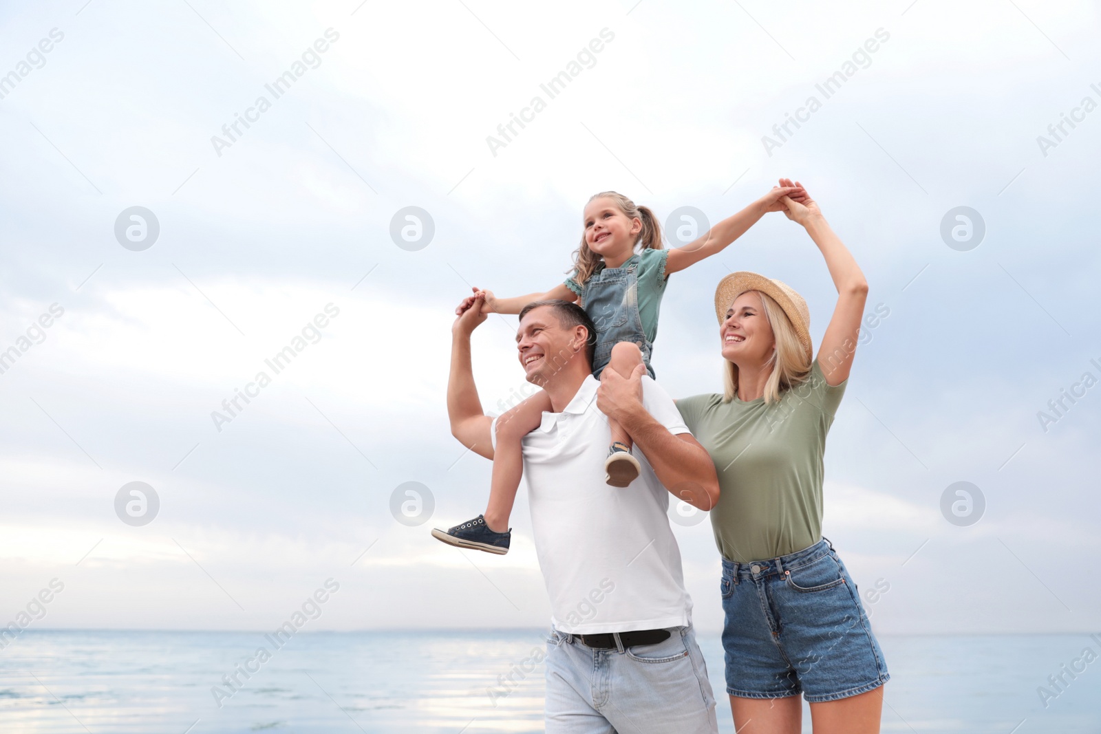 Photo of Happy family spending time together near sea on sunny summer day