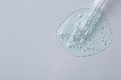 Pipette with cosmetic serum on white background, top view. Space for text