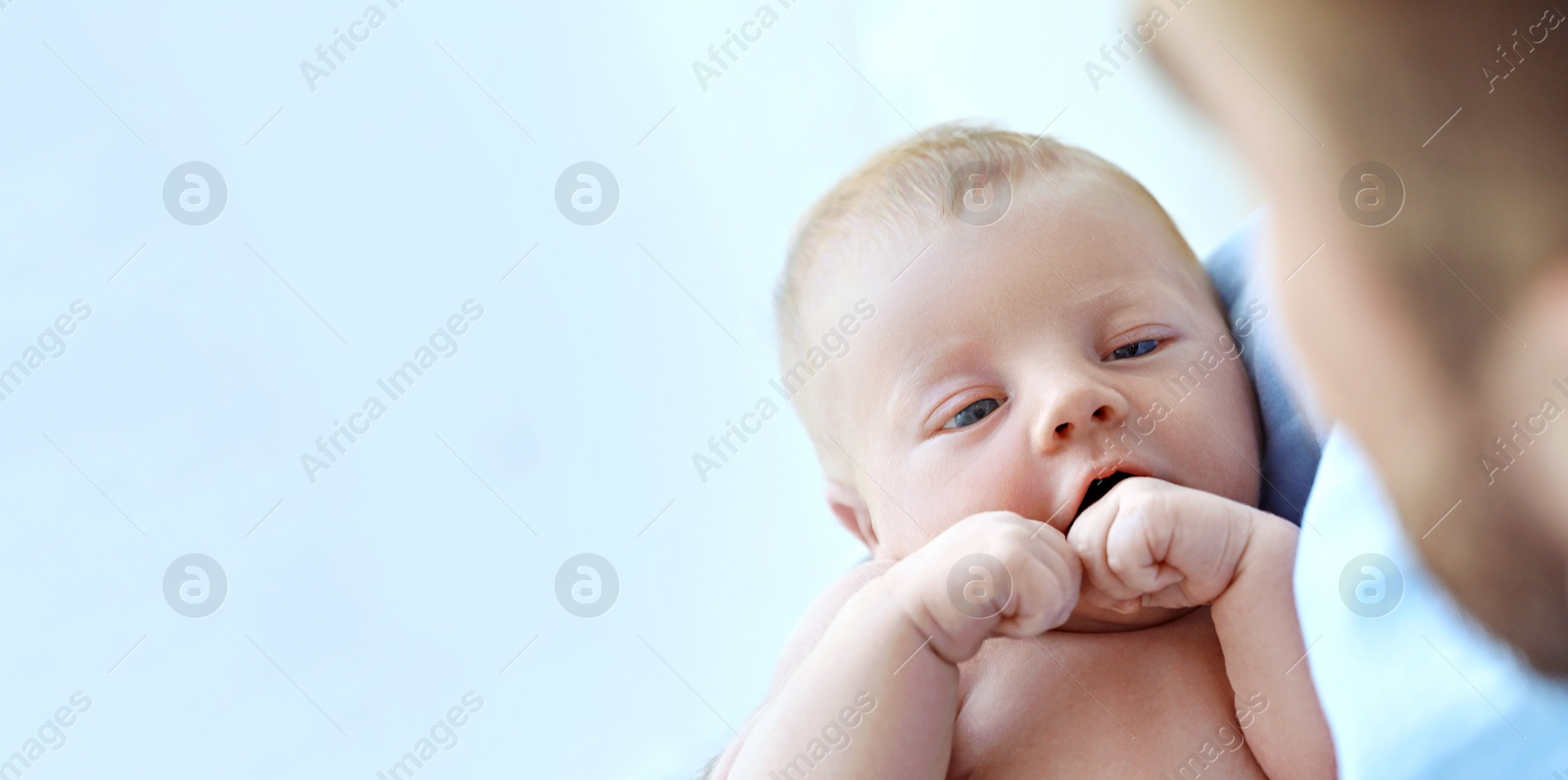 Image of Father holding his cute newborn baby at home, closeup view with space for text. Banner design