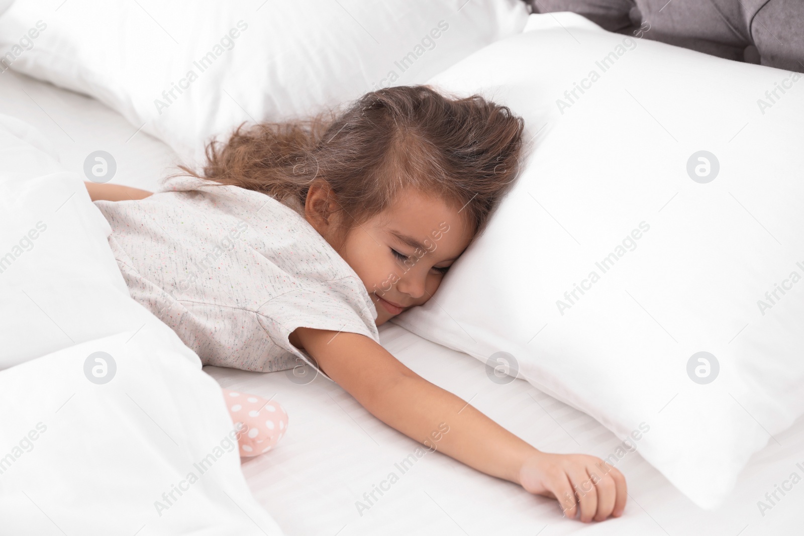 Photo of Cute little girl sleeping in cozy bed