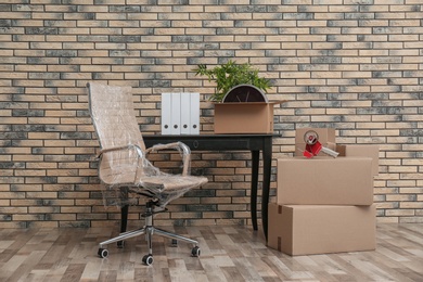 Photo of Furniture and moving boxes in empty office