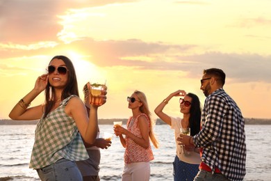 Photo of Woman with friends having fun near river at summer party