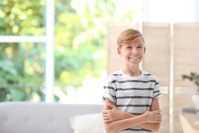 Photo of Portrait of young boy standing near window indoors