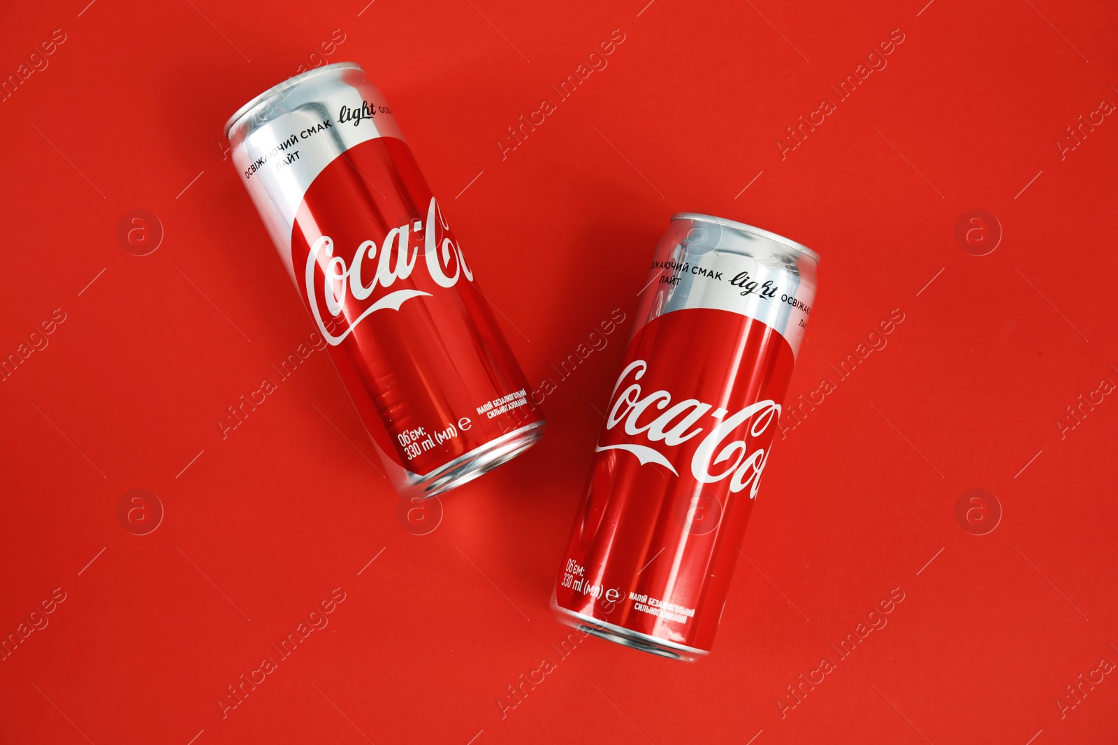 Photo of MYKOLAIV, UKRAINE - NOVEMBER 14, 2018: Coca-Cola cans on color background, top view