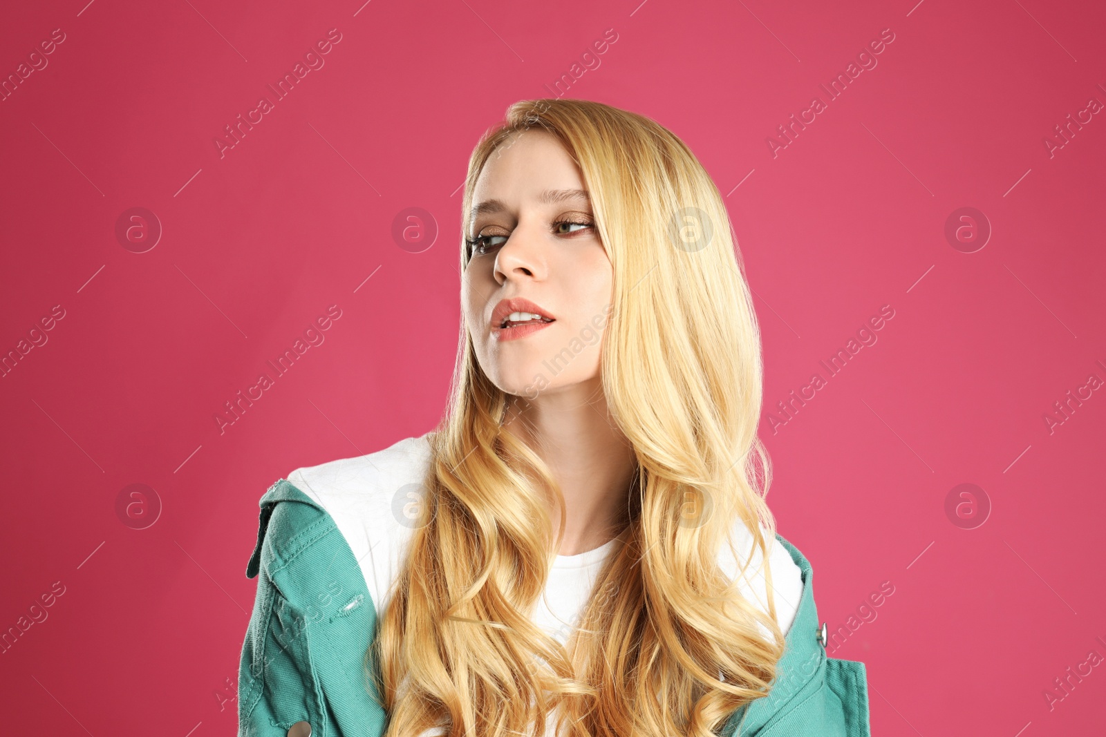 Photo of Portrait of beautiful young woman with dyed long hair on pink background