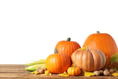 Composition with ripe pumpkins and autumn leaves on wooden table against white background. Happy Thanksgiving day