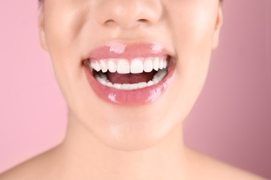 Photo of Beautiful young woman with healthy teeth on color background, closeup