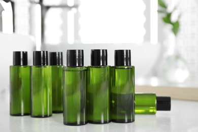 Photo of Mini bottles with cosmetic products on white table indoors