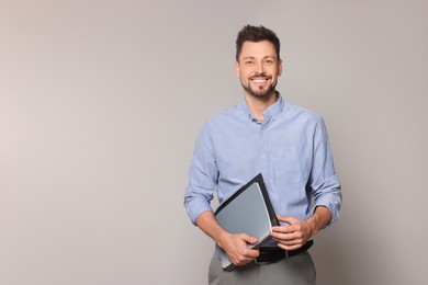 Photo of Happy teacher with stationery against beige background. Space for text